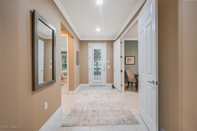 doorway with ornamental molding and light tile patterned floors