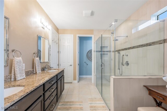 bathroom with a shower with shower door, tile patterned floors, and vanity