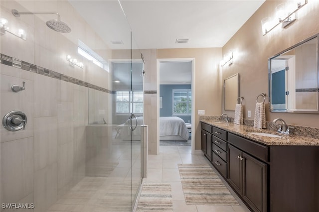 bathroom featuring tile patterned floors, a shower with door, and vanity