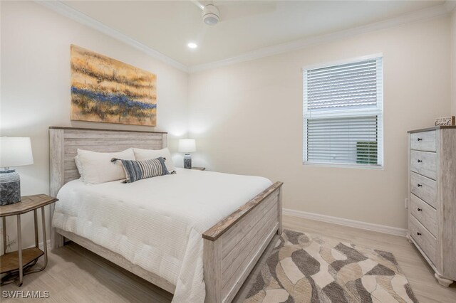 bedroom featuring crown molding, light hardwood / wood-style flooring, and ceiling fan