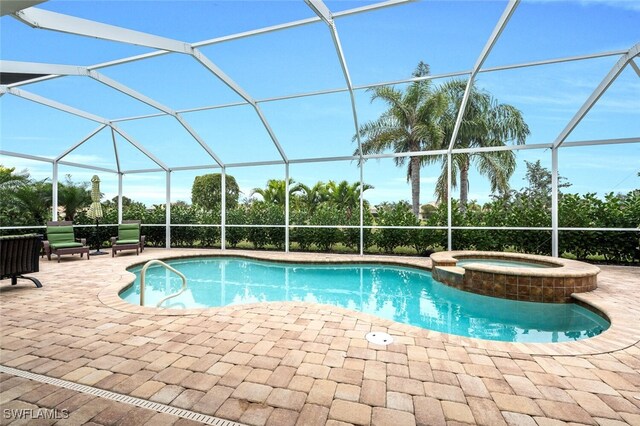 view of pool featuring glass enclosure, a patio area, and an in ground hot tub