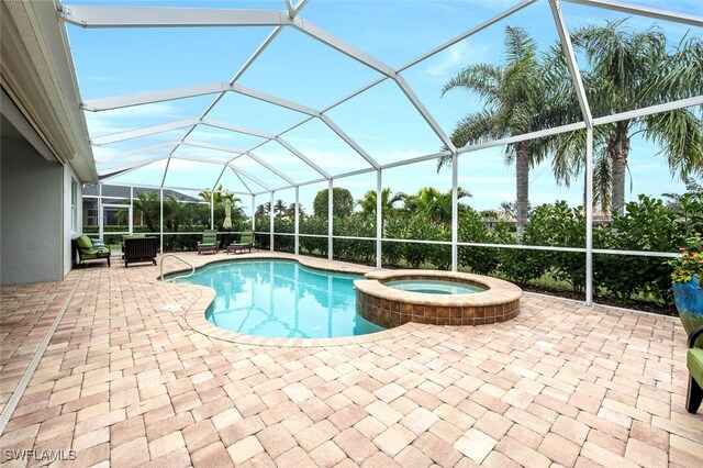 view of pool with a lanai, a pool with connected hot tub, and a patio