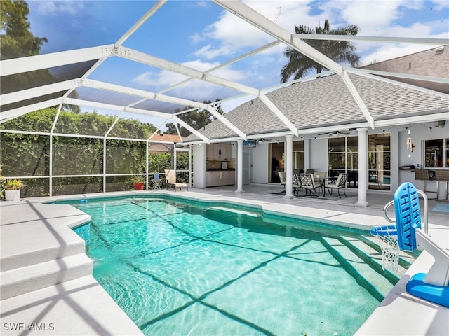 view of pool featuring ceiling fan, a patio area, and glass enclosure