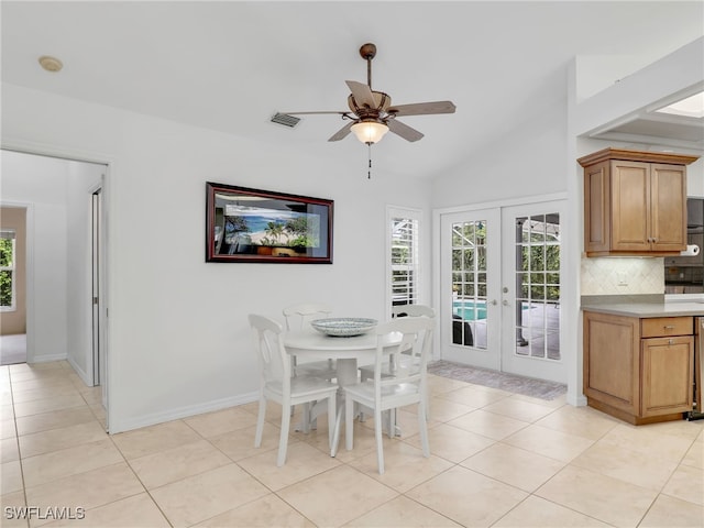 tiled dining room with ceiling fan, lofted ceiling, and french doors