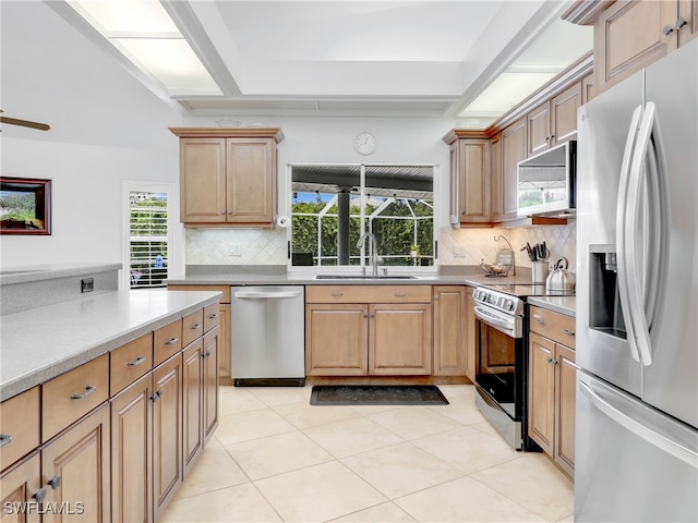 kitchen featuring light tile patterned floors, sink, appliances with stainless steel finishes, and tasteful backsplash