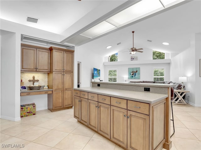 kitchen featuring light tile patterned floors, ceiling fan, backsplash, vaulted ceiling, and a kitchen island