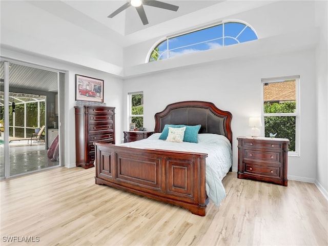 bedroom with ceiling fan, access to exterior, multiple windows, and light hardwood / wood-style floors