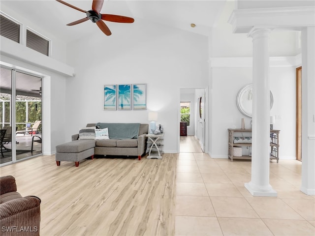 living room with decorative columns, a towering ceiling, and ceiling fan