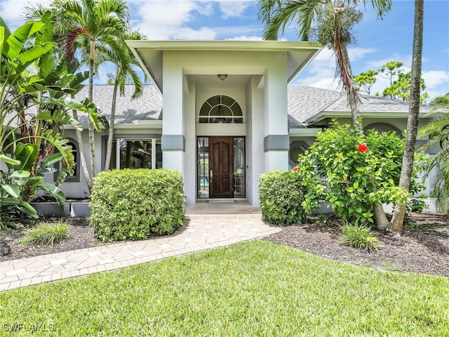 doorway to property with a lawn