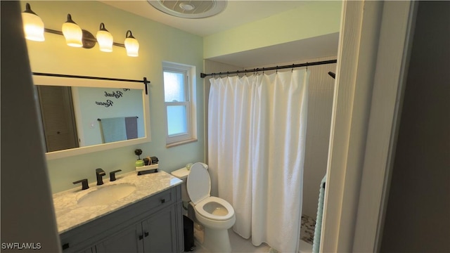 bathroom with toilet, vanity, and a shower with shower curtain