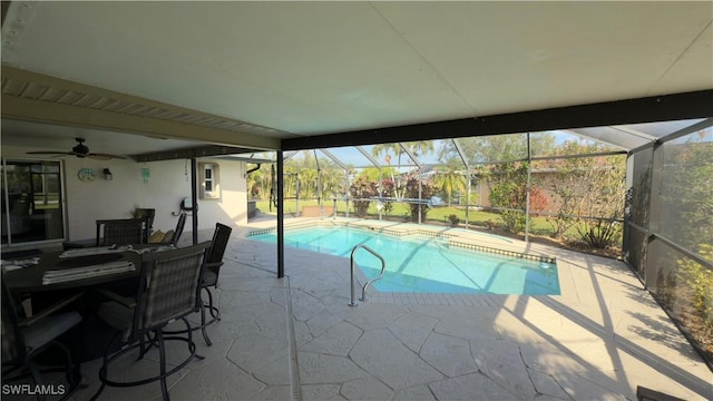 view of pool with glass enclosure, ceiling fan, and a patio