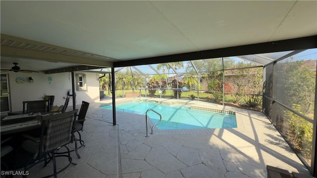 view of pool with glass enclosure and a patio area