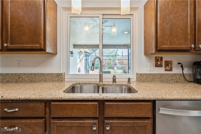 kitchen with sink, light stone countertops, and dishwasher