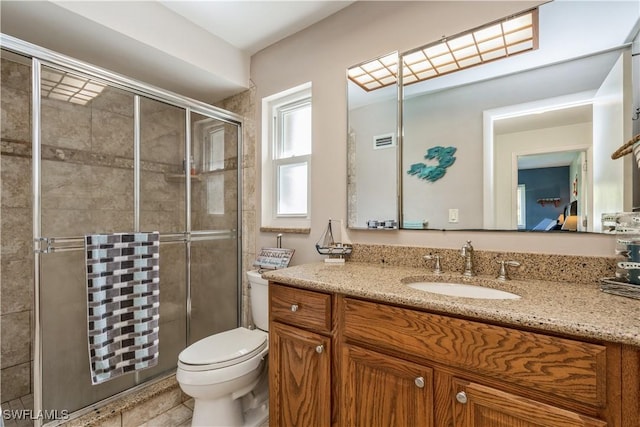 bathroom with vanity, toilet, and a shower with door