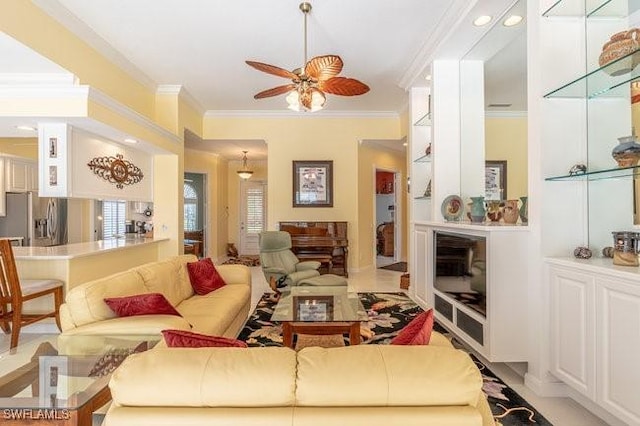 living room with ceiling fan and ornamental molding