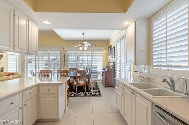 kitchen featuring light tile patterned floors, white cabinetry, a healthy amount of sunlight, and sink