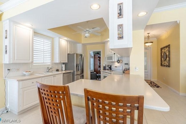 kitchen with a kitchen breakfast bar, white cabinetry, kitchen peninsula, and stainless steel appliances