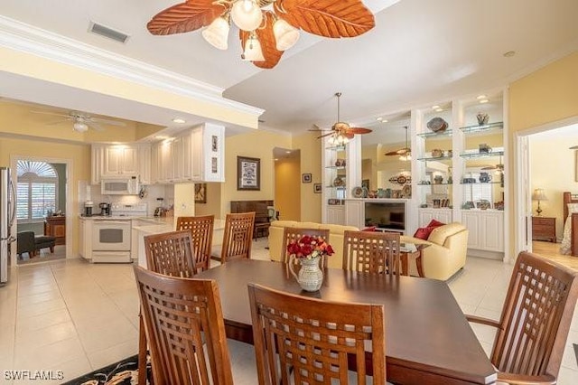 dining room featuring light tile patterned floors and crown molding