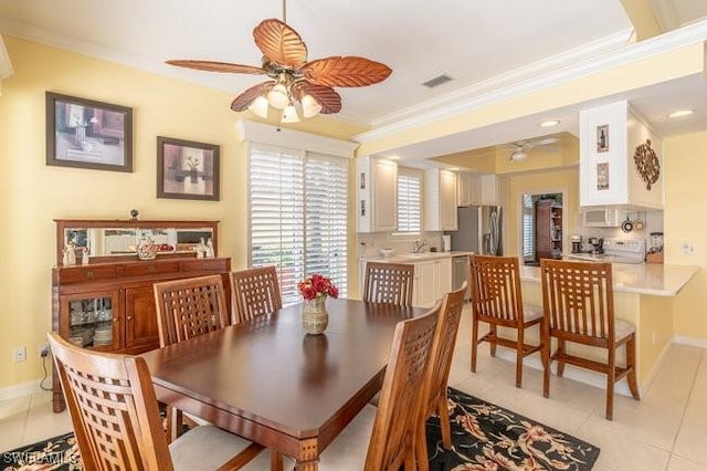 dining area featuring ceiling fan, light tile patterned floors, and ornamental molding