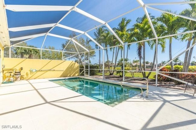 view of swimming pool featuring a lanai and a patio area