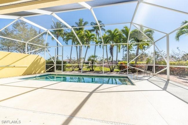 view of pool featuring glass enclosure and a patio area