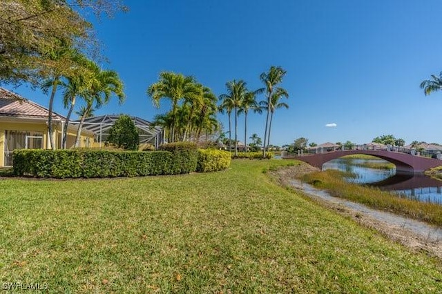 view of yard featuring a water view and glass enclosure