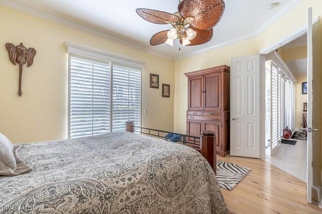 bedroom with ceiling fan, crown molding, and light hardwood / wood-style flooring