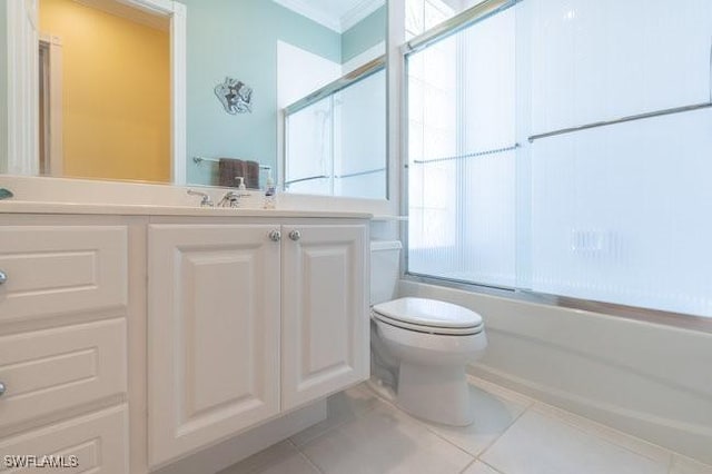 full bathroom with tile patterned floors, combined bath / shower with glass door, vanity, and toilet