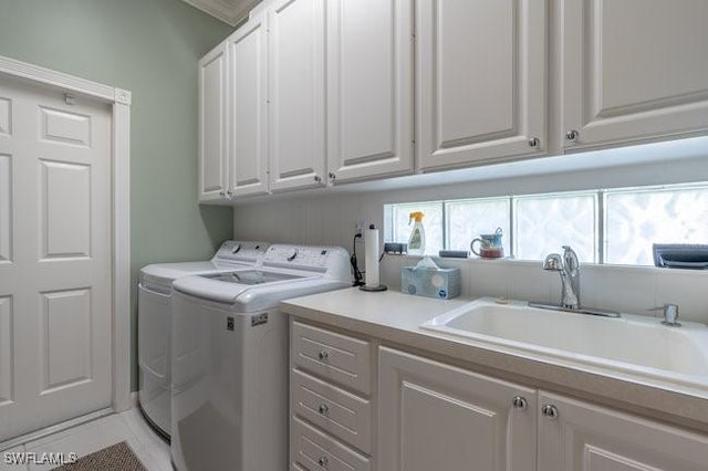 washroom featuring cabinets, separate washer and dryer, and sink