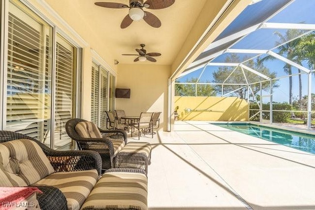 view of patio / terrace featuring ceiling fan and glass enclosure