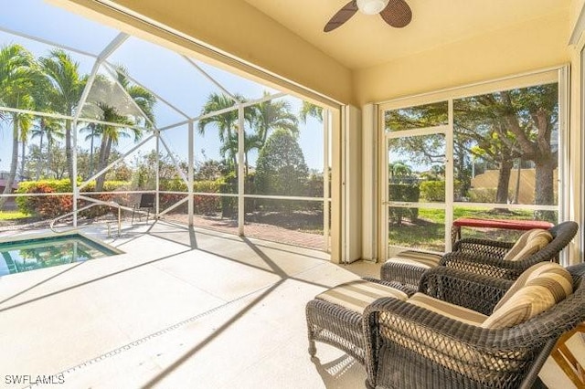 sunroom featuring ceiling fan and a pool