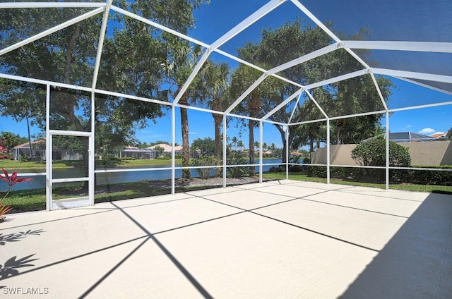 view of patio / terrace featuring a lanai and a water view