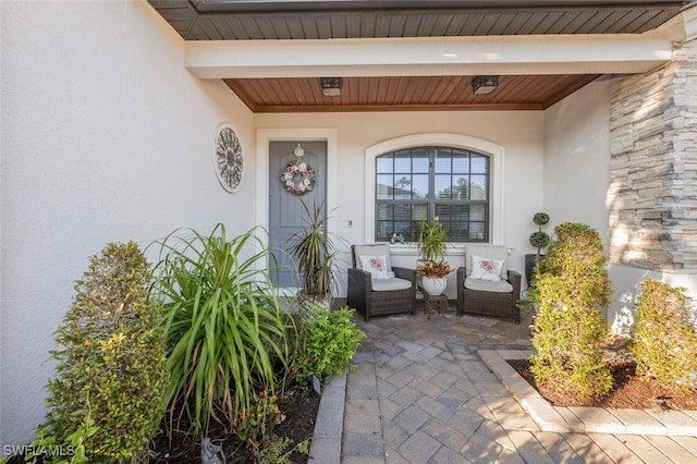 doorway to property featuring a patio and stucco siding