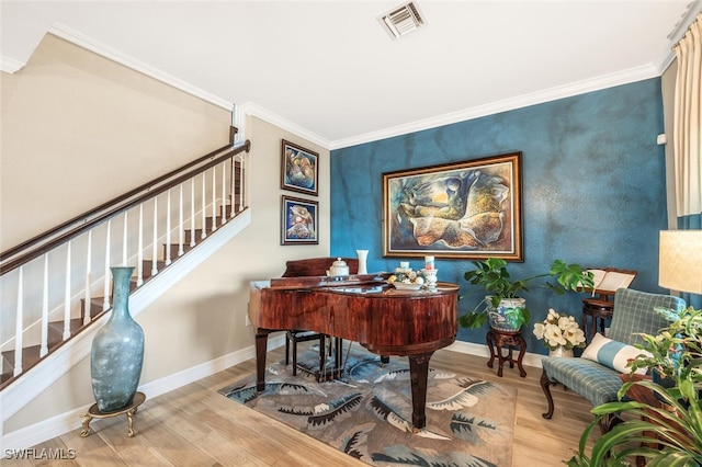 sitting room featuring ornamental molding, wood finished floors, visible vents, and baseboards