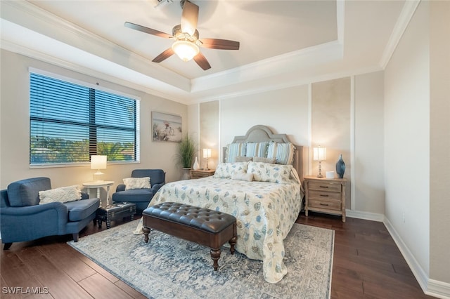 bedroom with ceiling fan, ornamental molding, dark hardwood / wood-style floors, and a tray ceiling