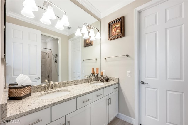 bathroom with crown molding, a tile shower, and a sink