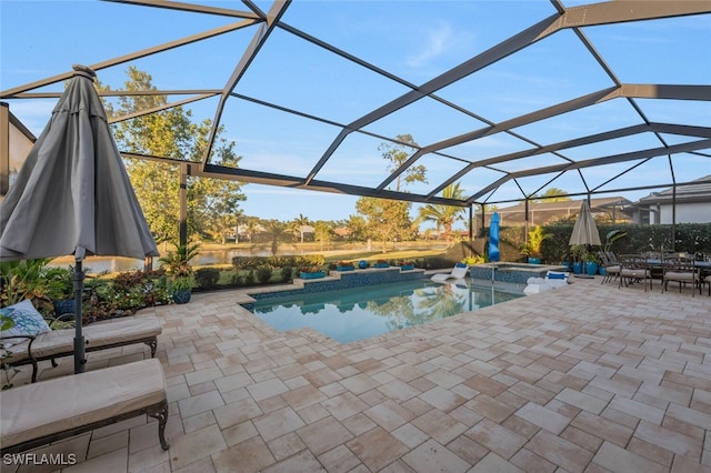 pool with glass enclosure, a patio area, and an in ground hot tub