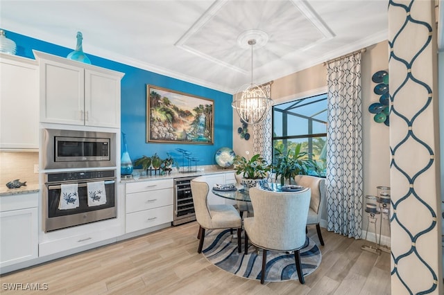 dining room featuring wine cooler, light wood-type flooring, crown molding, and a chandelier