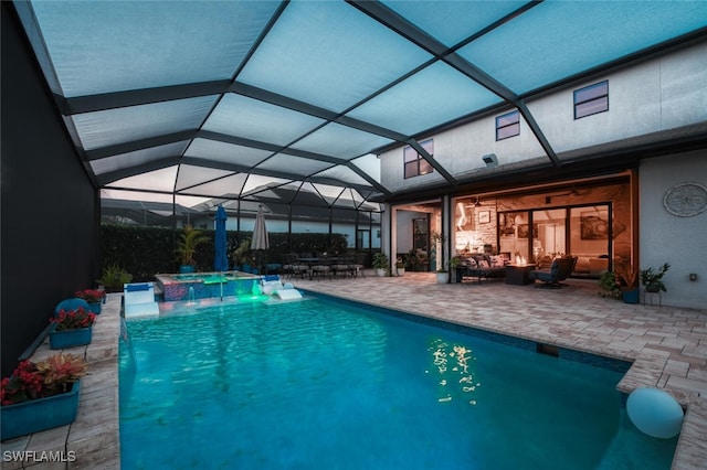 view of swimming pool with glass enclosure, an in ground hot tub, outdoor lounge area, a patio, and pool water feature