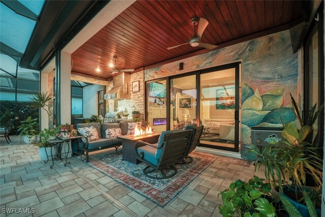 view of patio with ceiling fan and an outdoor living space with a fire pit