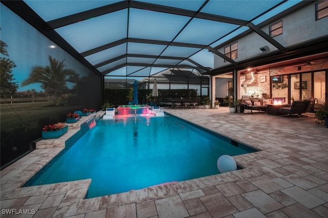 pool featuring an outdoor living space with a fire pit, a patio area, and a lanai