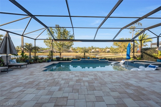 outdoor pool featuring glass enclosure, a patio, and an in ground hot tub