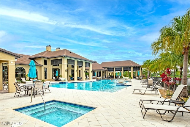 view of swimming pool with a patio area and a community hot tub