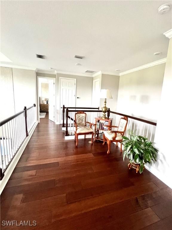 hall featuring dark wood-style floors, visible vents, and ornamental molding