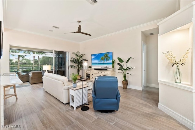 living room featuring crown molding, visible vents, light wood-style floors, ceiling fan, and baseboards