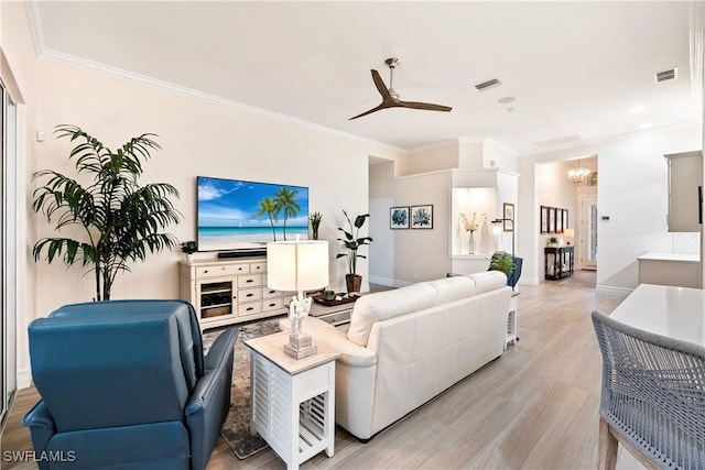 living room featuring ornamental molding, ceiling fan with notable chandelier, and light hardwood / wood-style flooring