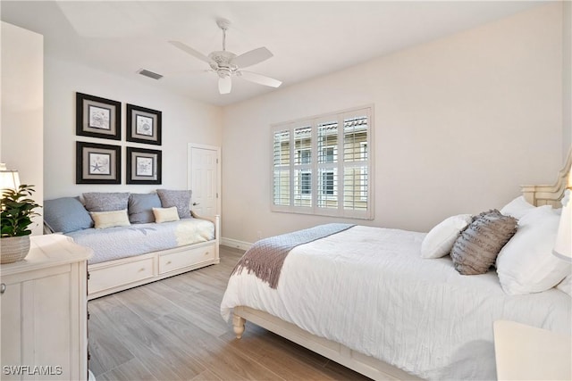 bedroom featuring light wood-style flooring, visible vents, ceiling fan, and baseboards