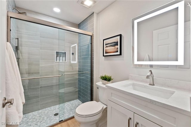 full bathroom with a stall shower, visible vents, vanity, and toilet