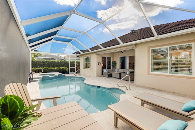 view of swimming pool featuring ceiling fan, a lanai, a patio area, a pool with connected hot tub, and an outdoor living space