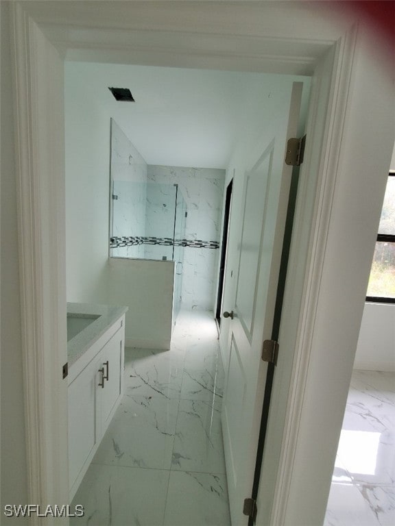 bathroom featuring an enclosed shower and vanity